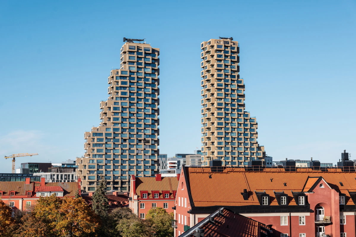 Norra Tornen rising above the tiled rooftops of Vasastan, Stockholm, on a clear autumn day.
